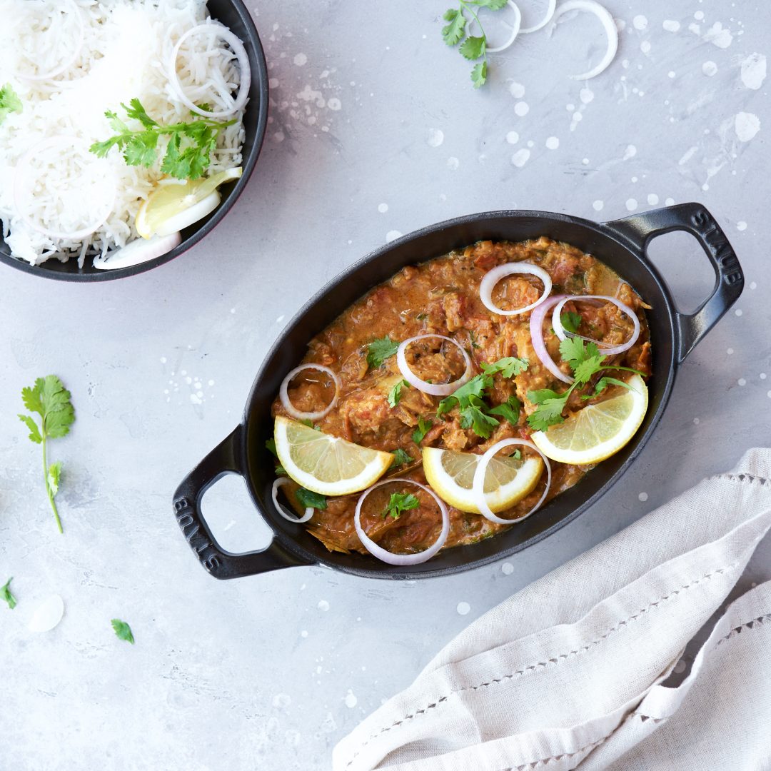 Spicy Chicken Latpata served with basmati rice and naan, garnished with fresh coriander.